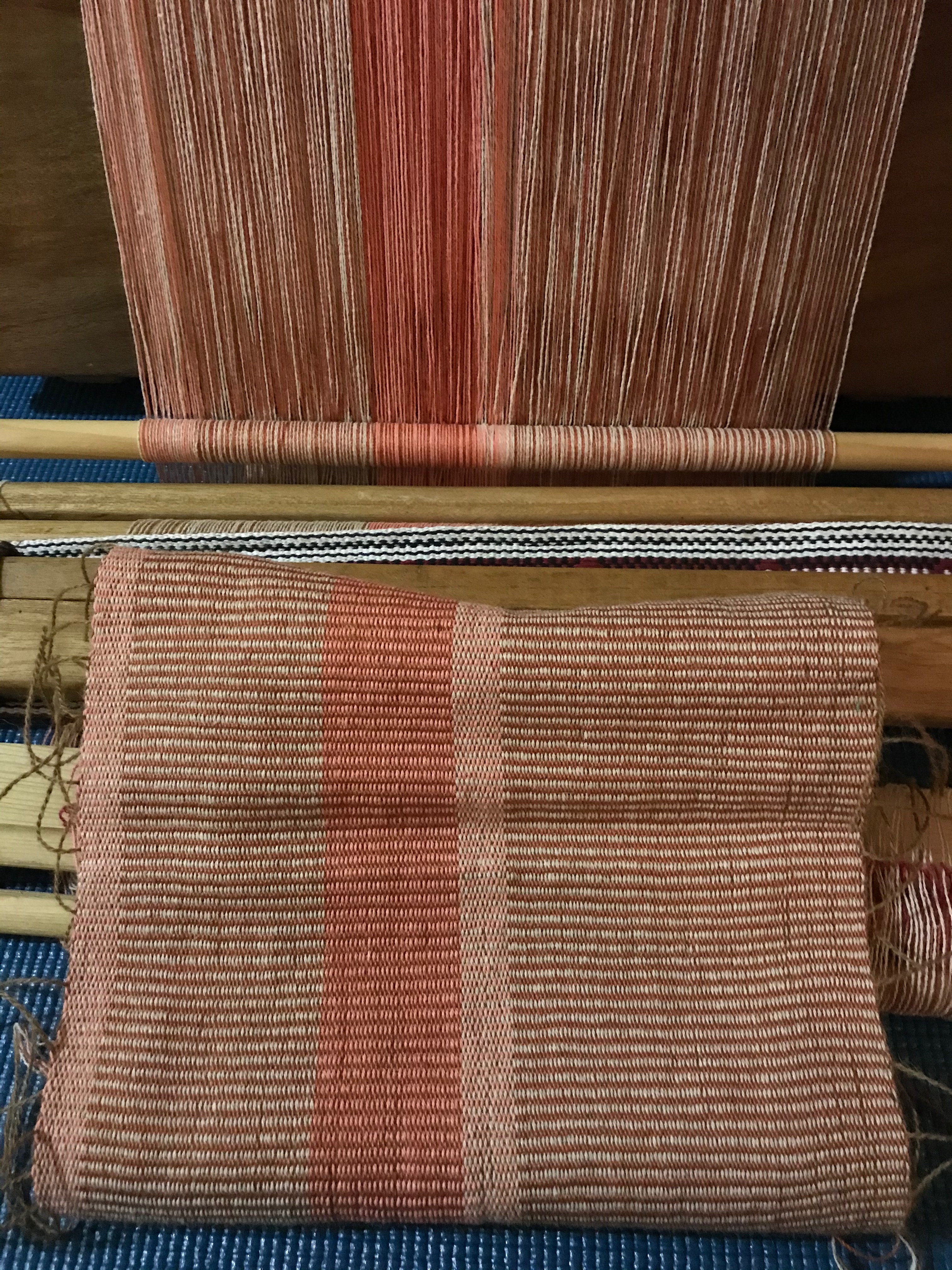 Photograph of an in-process weaving still attached to an indigenous Taiwanese backstrap loom