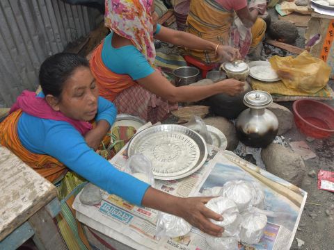 Boro women selling Pitha,  steamed rice cake