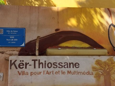 A sign welcoming everyone to the Kër Thiossane art and multimedia villa. In Wolof, Kër means home and Thiossane represents traditional Senegalese culture.