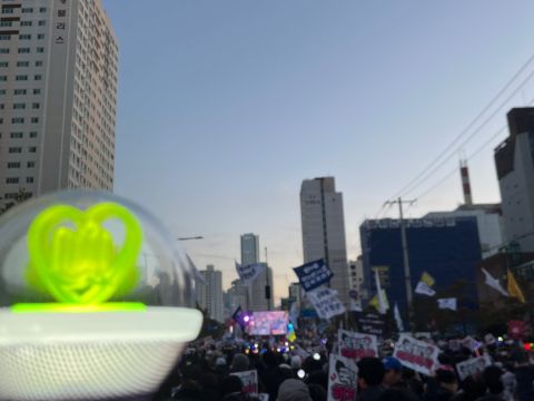 A K-Pop light stick in front of the protests in Seoul following the martial law announcement of Yoon Suk Yeol; Credit: Sewon Park (2024)