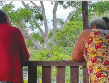 Two women from the Iriri River community in the Amazon, Brazil looking out into the forest